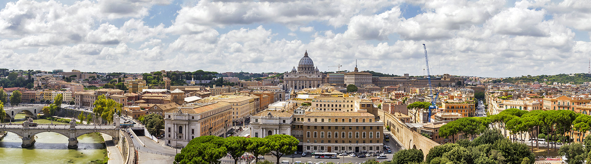 Rooftops of Rome and a bridge over the Tiber, with St Peter’s dome beyond